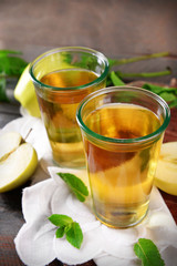 Glasses of apple juice on wooden table, closeup