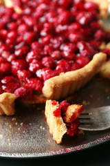 Piece of tart with raspberries on tray, close-up