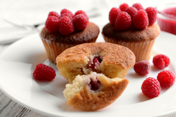 Delicious cupcakes with berries on plate close up