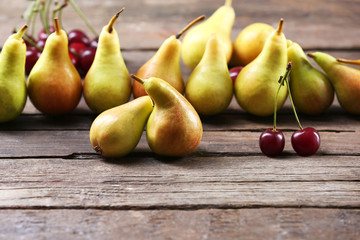 Naklejka na ściany i meble Ripe pears and cherries on wooden table close up