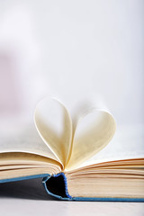 Pages of book curved into heart shape, close up