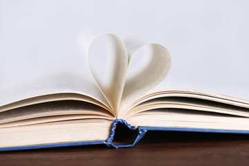 Pages of book curved into heart shape, close up