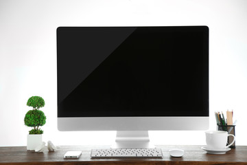 Computer on wooden table with blank white background