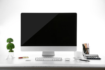 Computer on wooden table with blank white background