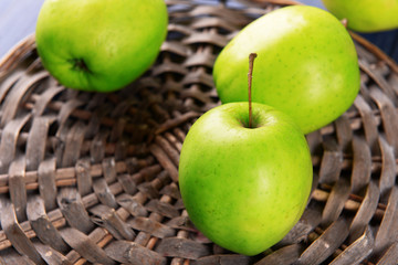 Green apples on wicker board, closeup