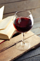 Beautiful composition with glass of wine with old books on table close up