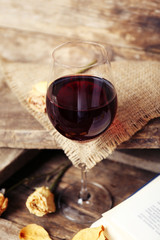 Beautiful composition with glass of wine with old book on table close up
