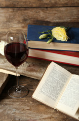 Beautiful composition with glass of wine with old books on table close up
