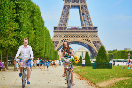 Young couple using bicycles in Paris, France