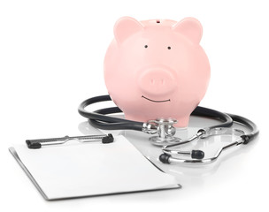 Piggy bank with stethoscope and clipboard isolated on white