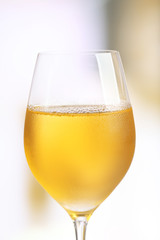 Glass of wine on light blurred background