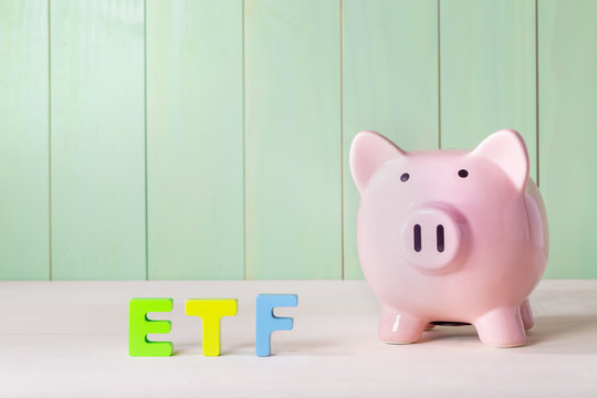 Exchange Traded Funds theme with wood block letters and piggy bank
