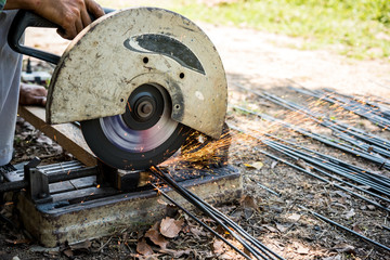 worker cutting steel rod