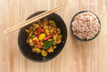 Fried spicy pork and sato with rice berry on wood background 