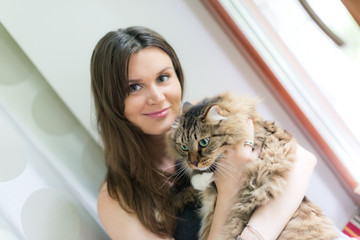 beautiful smiling brunette girl and her ginger cat