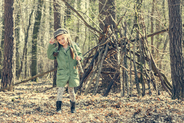 little cute girl near her hut in the forest