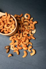 heap cashew nuts and salt on black background