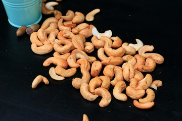 heap cashew nuts and salt on black background