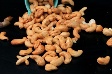 heap cashew nuts and salt on black background