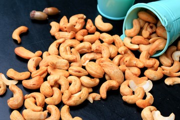 heap cashew nuts and salt on black background