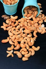 heap cashew nuts and salt on black background