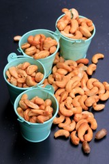 heap cashew nuts and salt on black background