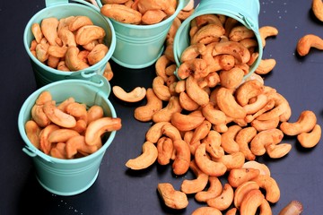 heap cashew nuts and salt on black background