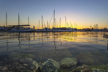 Obraz premium The Setting behind the Floating / As the sun goes down in the background of the Marina at Pt. Lincoln, South Australia.