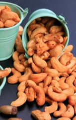 heap cashew nuts and salt on black background
