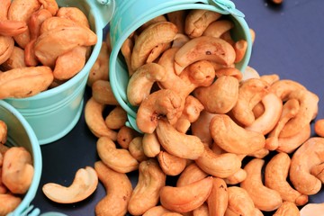 heap cashew nuts and salt on black background
