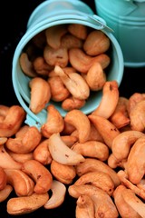 heap cashew nuts and salt on black background