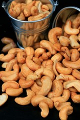 heap cashew nuts and salt on black background