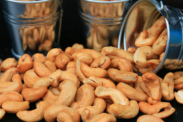 heap cashew nuts and salt on black background
