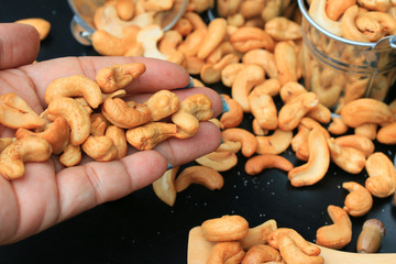 heap cashew nuts and salt on black background