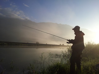 pescatore sul fiume all'alba