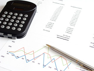 Jahresbilanz mit Kugelschreiber und Taschenrechner