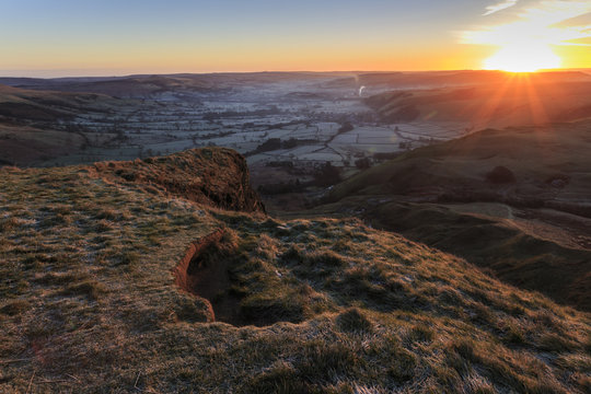 Mam Tor (Shivering Mountain), exposed east face strata lit by rising sun in winter, Castleton, Peak District, Derbyshire