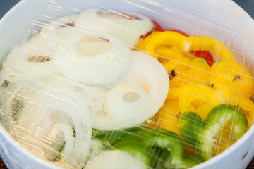 Vegetables in a glass bowl on the plastic wrap.