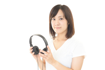 ヘッドフォンを持つ女性