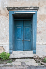 Fototapeta na wymiar Old wooden blue door in the wall of old building.