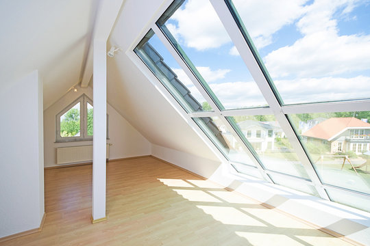 helles Dachgeschosszimmer mit gro&szlig;em Fenster