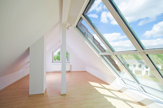 helles Dachgeschosszimmer mit großem Fenster