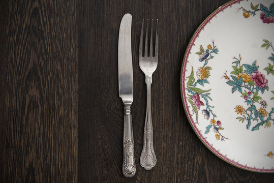 Vintage cutlery and crockery on wooden table