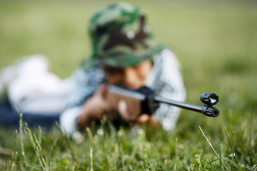 little boy with airgun outdoors