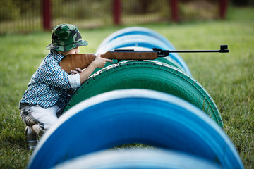 little boy with airgun outdoors
