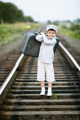 boy with suitcase on railroad