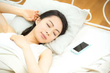 スマートフォン・眠る若い女性