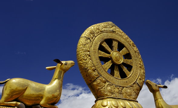 Golden Wheel of Dharma and deer sculptures on the sacred Jokhang Temple roof, Barkhor Square, Lhasa, Tibet, China 