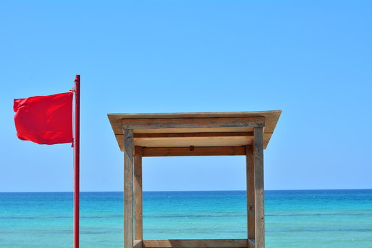 The red falg on the sea and the house of the lifeguard