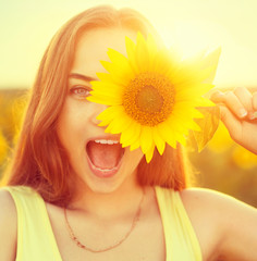 Beauty joyful teenage girl with sunflower 